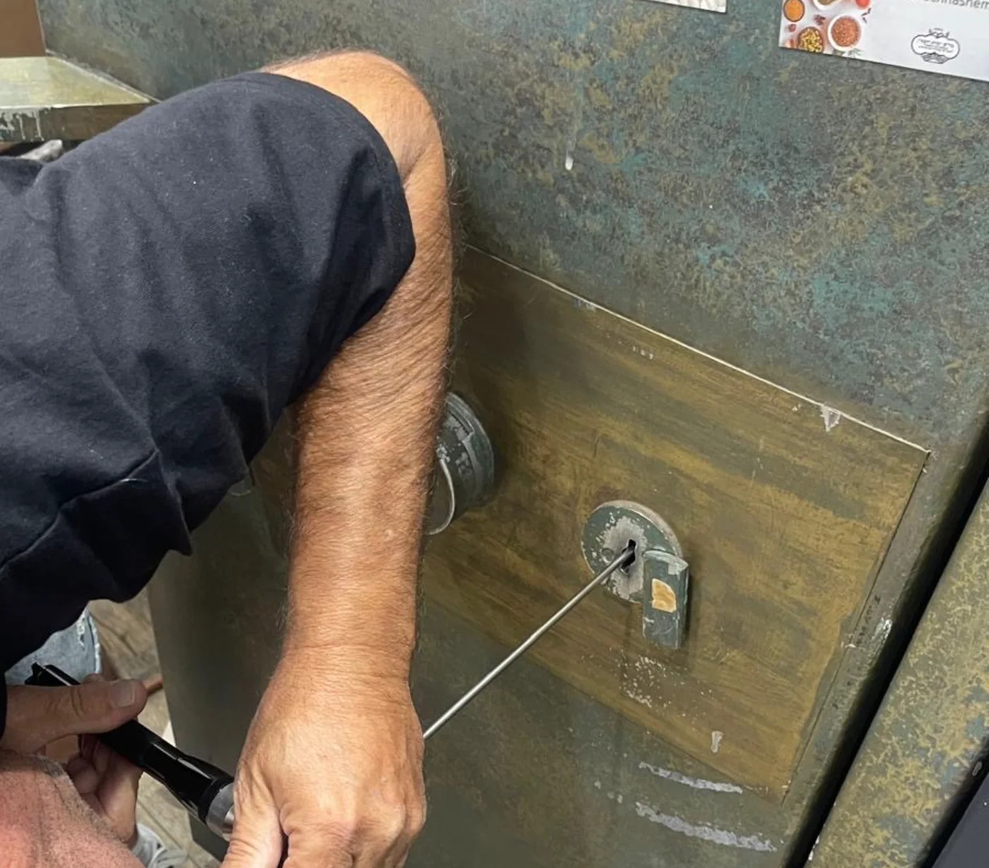 שלום מגירה, טכנאי כספות מוסמך, בודק מנגנון של כספת כבדה