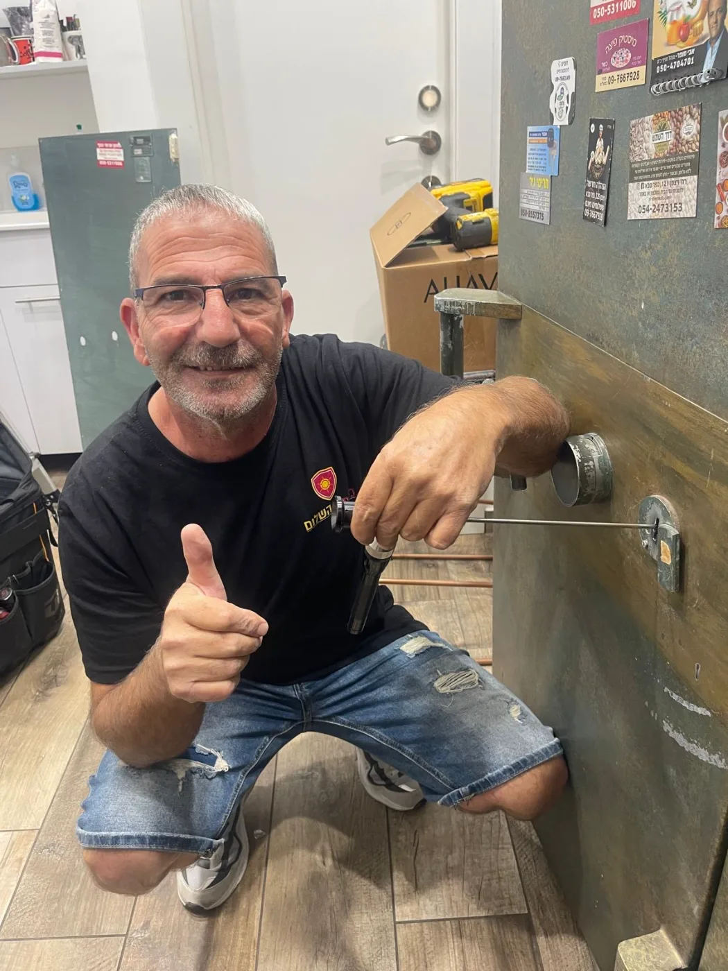 שלום מגירה, טכנאי כספות מוסמך, ליד כספת פלדה ותיקה שנפתחה בשיטה שקטה ללא נזק